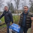 two adults carry a generator