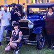 A picture of the cast of Mystery 207's 1920s show. They're dressed like mobsters, flappers, cops, and teetotalers, and pose around a vintage car (maybe a Model T?).
