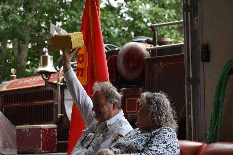 Retiring Hope Fire Chief Clarence Keller raises the gift that emcee Camden Fire Chief Chris Farley thought was an appropriate "Chiefly" gift for Keller. (Photo by Sarah Thompson)