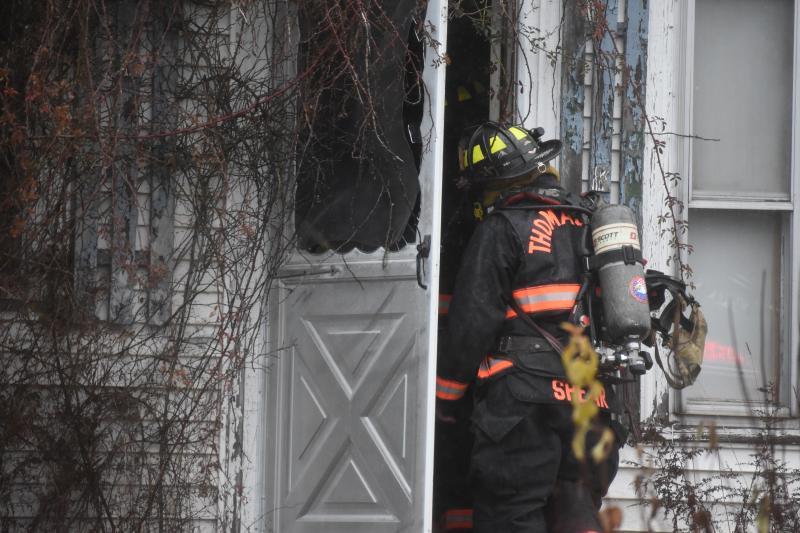 firefighter looks into the entryway of a house