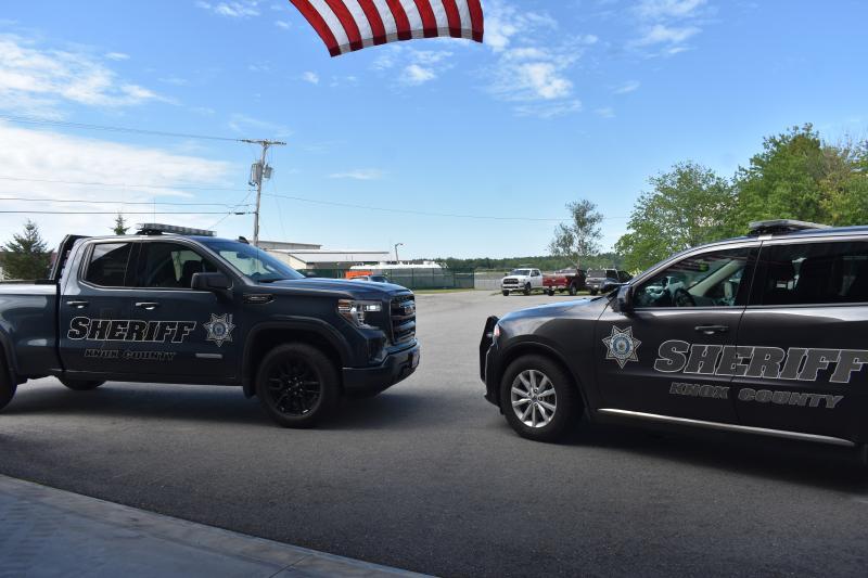 KCSO truck and SUV under American flag