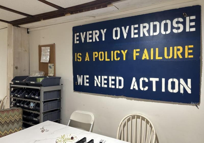 A sign that reads, “Every overdose is a policy failure. We need action.” 