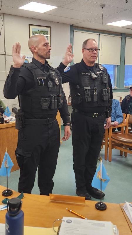 two officers raise their right hands