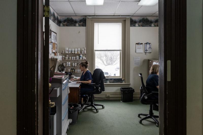 two women reviewing paperwork while sitting at desks