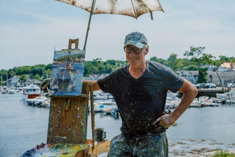 man poses with his painting