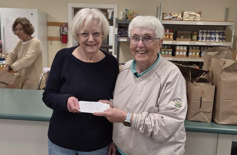 Goose River Golf Club Ladies League Manager Faith Vautour (R) presents a $1,000 check to Penny Baum, vice president of the Camden Area Christian Food Pantry Board of Directors.