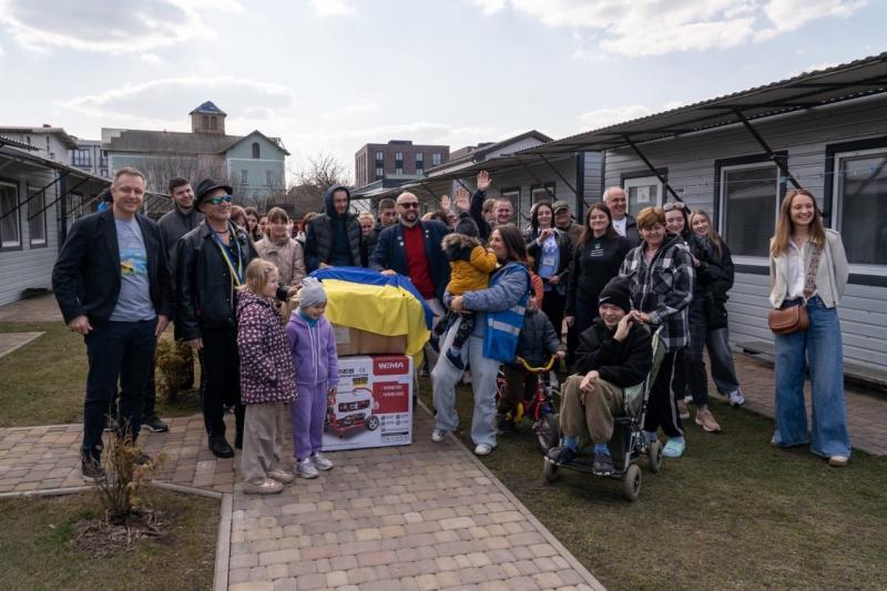 large, multi-generation group poses with donation