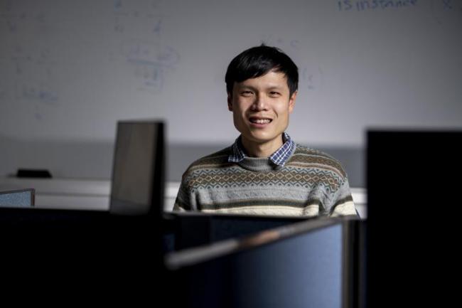 Male between computers, dry erase board