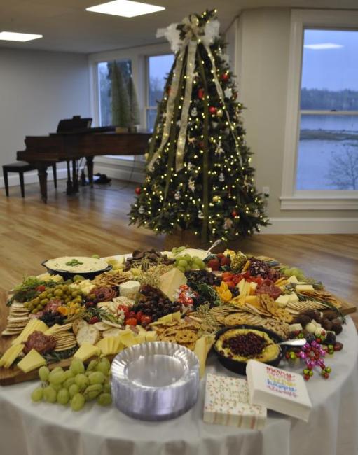 Snack table in foreground, decorated tree and piano in background