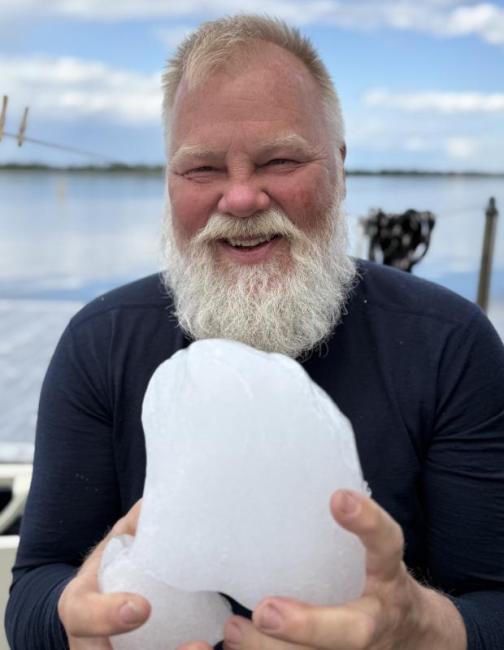 Man holding piece of iceberg