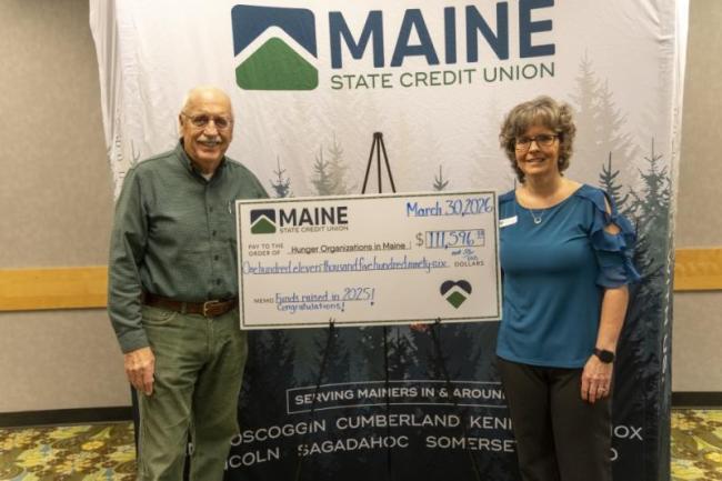 Two adults with oversized check