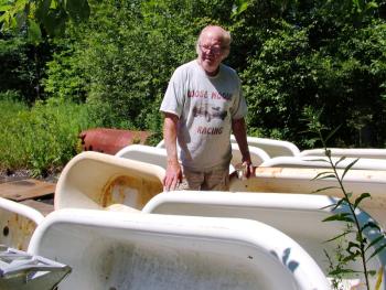 Bill Coughlin, a.k.a. "Mr. Tubs," with some of the dozens of cast iron tubs he keeps outside his Belmont workshop. (Photo by Ethan Andrews) Bill Coughlin, a.k.a. "Mr. Tubs," with some of the dozens of cast iron tubs he keeps outside his Belmont workshop. (Photo by Ethan Andrews)
