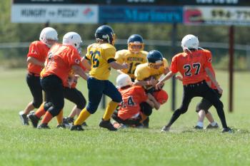 A medomak runner gets tackled behind the line of scrimmage. Photo by Ron Hawkes