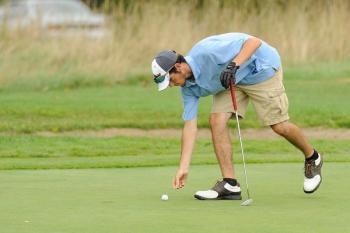 Oceanside's Jordan Carter marks his ball near the cup after a nice chip shot onto the green. Photo by Ron Hawkes
