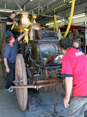 Camden firefighters join with Andy Swift of Firefly Restorations in sprucing up the town's antique horse-drawn steam fire pumper as a way to do something good on the anniversary of 9/11.