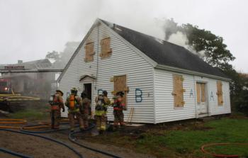 As fire builds inside the donated home, an attack crew readies to enter and practice their skills. (Photo by Holly S. Edwards)