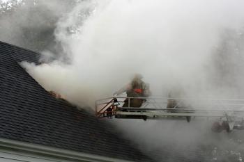 Saturday's winds whips the smoke around, momentarily shrouding firefighters before clearing again. (Photo by Holly S. Edwards)