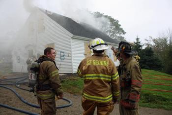 Safety officer Randall Elwell, from St. George Fire Department, points to where he suspects fire is building inside the home Saturday morning. (Photo by Holly S. Edwards)