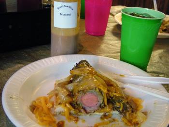 A cross-section of Pig Out's naughty signature dish, the "Pig Bomb," reveals the hot dog at the center of two additional layers of pork, onions, cheese and barbecue sauce. (Photo by Ethan Andrews)