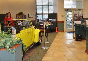 The 1968 Volkswagen Beetle sits in the lobby of Camden National Bank, in downtown Camden. Its owner, Josey Lewis, an employee of the Camden downtown branch of the bank, stands beside it. She always wanted a beetle, and four years ago, bought herself one. The license plate reads "Sew Nutt", reflecting her hobby as a seamstress. (Photo by Lynda Clancy)