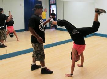 Boston dance instructor Chickey shows Kea Tesseyman how to do a breaking move.