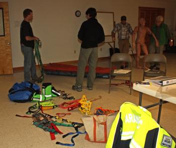 A mannikin is brought over to practice lashing, using straps and a litter. (Photo by Holly S. Edwards)