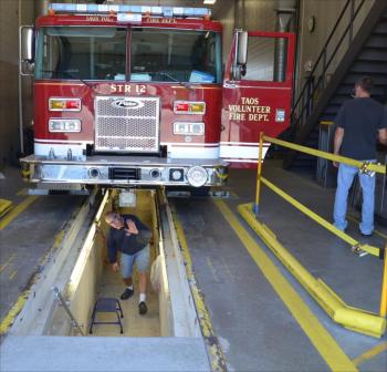 Don Rucci checks the alignment of a new truck, with Ron Weber. (Photo by Lynda Clancy)