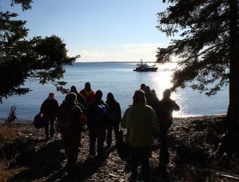The volunteers playing plane crash victims in the Oct. 13 mass casualty drill arrive on the beach with a Coast Guard Auxiliary vessel in the background. (Photo by Holly S. Edwards)