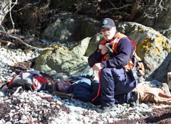 Radioing in injuries and calling for immediate transport of a 'gravely injured victim' during Saturday's mass casualty drill on Lasell Island. (Photo by Holly S. Edwards)