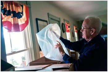 BROOKS – Town office volunteer Jimmy Mulcahey looks at packaging provided by Veolia Environmental Services for collecting used fluorescent light bulbs. Officials hope the program will make disposal of the bulbs easier than bringing them to the transfer station in Thorndike.