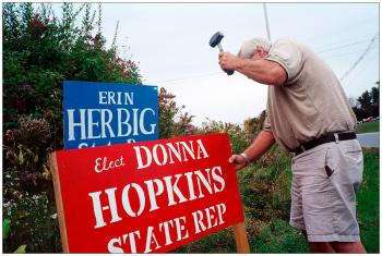 BELFAST – Stephen Hopkins of Belmont fixes one of his wife's campaign signs next to a sign of her rival, incumbent House District 43 Rep. Erin Herbig.