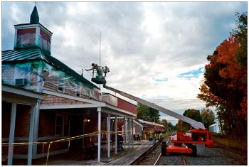 UNITY – A worker repaints the metal roof of the railroad depot. The station is being redeveloped as a commercial property.