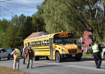 Robert Smith, driver of No. 14 bus of School Adminstrative District 28 (Camden-Rockport) waits patiently for crews to disconnect the power line that landed on the top of his bus so he could safely drive home. (Photo by Lynda Clancy)