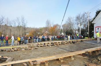 Hundreds of people showed up in Lincolnville Saturday morning, Oct. 27, to help pull the old Center School building across Route 52 to its new home on the former site of the Dean & Eugley Garage. (Photo courtesy Barbara Hatch)