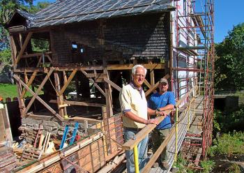 Tony Grassi, of Camden, left, is giving the 19th-Century Freedom Falls Mill a 21st-Century makeover as a commercial property, complete with a hydroelectric generator that will supply the power for the building. Grassi is pictured at the mill with project foreman Jim Rorden, of Cold Mountain Builders. (Photo by Ethan Andrews)