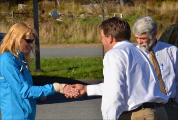 Marianne Smith shakes hands with Stephan Keenan, of Keenan Auction Company, just before going to cast the winning bid at the foreclosure auction of Farmers Fare, on the corner of Cross Street and Route 90 in Rockport on Oct. 18. Her husband, Stuart, is to her left. (Photo by Lynda Clancy)