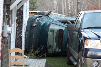 The overturned car came from the right of the photo, hit the back of this pickup truck and then struck Ray Lovejoy's home, breaking a window. (Photo by Holly S. Edwards)