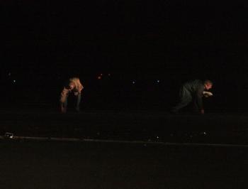 Knox County Regional Airport Manager Jeff Northgraves, right, and anothe rman pick up debris from Friday night's plane crash. (Photo by Holly S. Edwards)