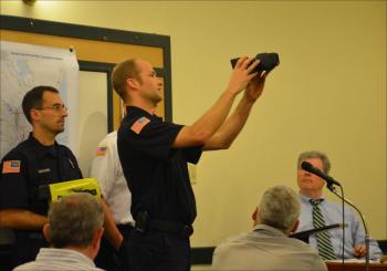 Camden firefighter Cheyne Hansen exhibits the town's new thermal imaging camera to the Select Board Nov. 13. (Photo by Lynda Clancy)