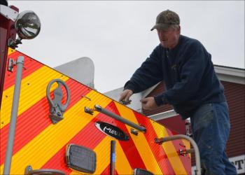 Assistant Fire Chief Don Filington takes his knife out and cleans off a little stray aluminum left from the manufacturing process.