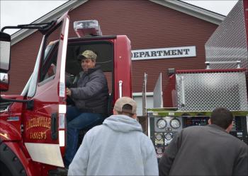 Lincolnville firefighter Todd Young tests the driver's seat. (Photo by Lynda Clancy)
