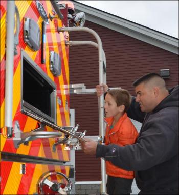 Assistant Fire Chief Peter Rollins and Jordan Peasley review the truck's rear features. (Photo by Lynda Clancy)