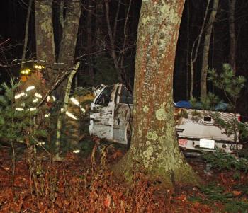 A pickup truck with a crushed roof sits in the woods off outer Washington Street (Route 105) Friday morning. (Photo by Holly S. Edwards)