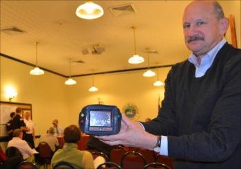 Camden resident, and former selectman and Camden firefighter, Jim Elliott gets a feel for the new $9,500 thermal imaging camera that has been acquired by the Camden Fire Department — thanks in part to a $5,000 donation from the Lowe family. Elliott trained on the original thermal imaging camera that Camden purchased in the 1990s. It is a heavy dinosaur compared to this new one, he said. (Photo by Lynda Clancy)