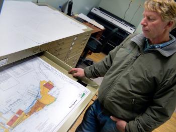 Front Street Shipyard President JB Turner with drawings of the Shipyard property and proposed additions. Turner and fellow representatives of the business anticipate making a formal presentation of their ideas, some of which would require the use of city property at the Dec. 4 City Council meeting. (Photo by Ethan Andrews)