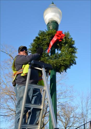 Camden town employee Tracy Harford was decorating the town Nov. 20 with fresh wreaths made by the Camden Garden Club. (Photo by Lynda Clancy)