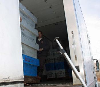 Pallets loaded with crates of lobsters are moved from one truck...(Photo by Holly S. Edwards)