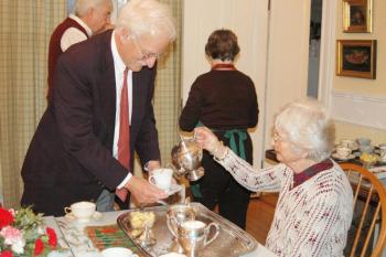 Marie Underwood pours a cup of tea for Dr. David Crofoot. (Photo courtesy Toni Mailloux)