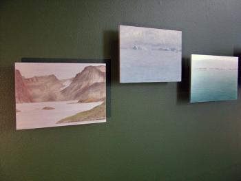 Small paintings by Lisa Lebofsky. At far left, a retreating glacier peeks between two mountains but no longer reaches the sea (Photo by Ethan Andrews)