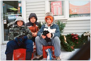 BELMONT - Young salesmen Kolby, Caleb and Jacob attend a display of holiday wreaths and a "kissing ball" outside Maritime Farms. Asked what a kissing ball was, Jacob, far right, pointed to a globe of evergreen boughs and ribbon hanging from a nearby ice machine.